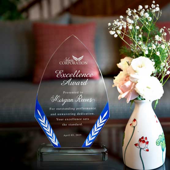 Custom Diamond Glass Award For Excellence With Logo And Blue Edges And Wheat Patterns And Base On Coffee Table With Flowers
