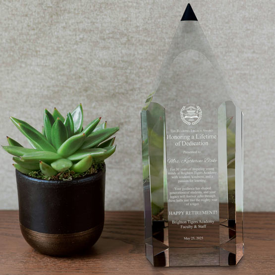 Custom Pencil Shaped Glass Award For Lifetime Dedication With Happy Retirement Message On Shelf With Potted Plant