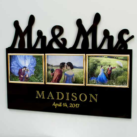 Personalized Mr. & Mrs. acrylic wedding frame displayed on a wall, showing 3 landscape photos with their names and date printed.