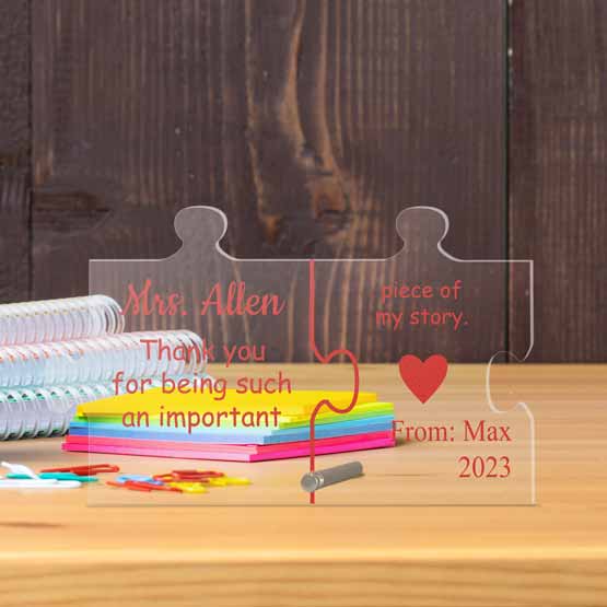 Personalized Teacher and Mentor gift of a freestanding acrylic puzzle piece, with the name of the teacher and child on a desk