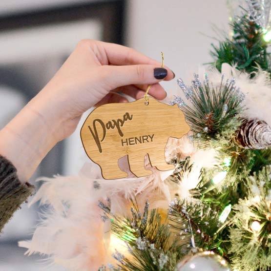 Bamboo laser cut bear ornament engraved to represent a family member being hung on a Holiday tree. Golden string included