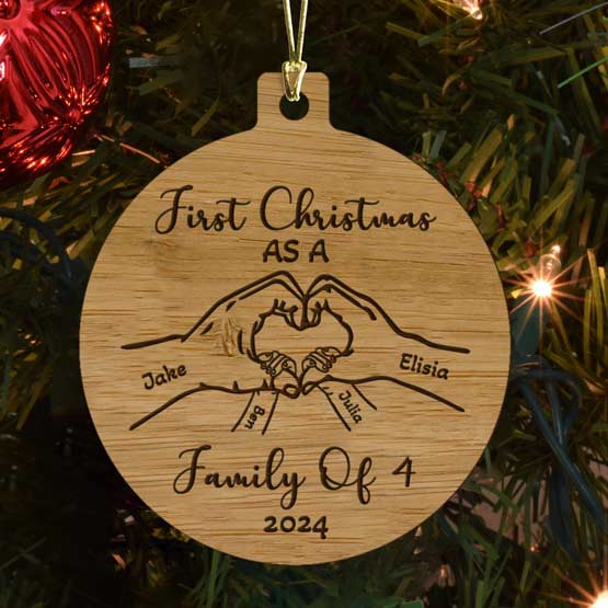 Bamboo Christmas Ornament With Custom Art Of Hands Making Heart And First Christmas As Family Of 4 Text Hanging On Tree