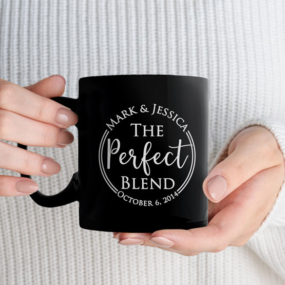 Custom Engraved 11 oz Black Ceramic Mug held by woman with sample engraving for Mark and Jessica