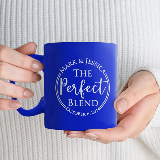 Custom Engraved 11 oz Blue Ceramic Mug held by woman with sample engraving for Mark and Jessica