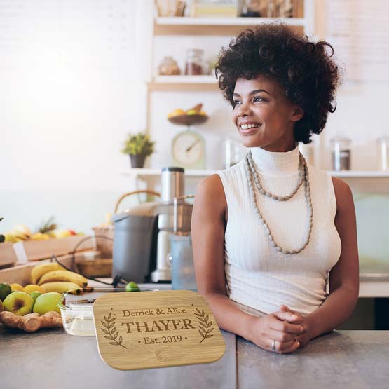 Young Black Woman Leaning On Kitchen Counter With Custom Rectangle Glass Baking Dish And Bamboo Lid Featuring Family Name