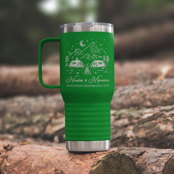 Custom Engraved 20 oz Green Tumbler on a wooden log with a sample engraving for Nicolas & Mariann