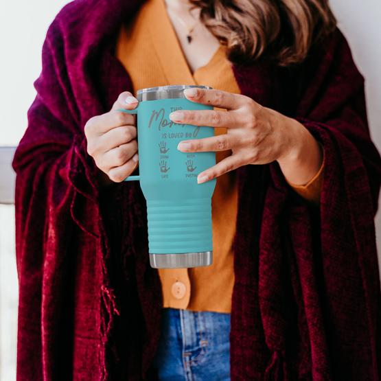 This Mommy is Loved By Teal Coffee Tumbler with Handle. This is held by woman in sweater.