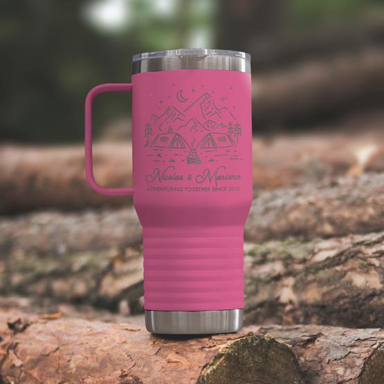 Custom Engraved 20 oz Pink Tumbler on a wooden log with a sample engraving for Nicolas & Mariann