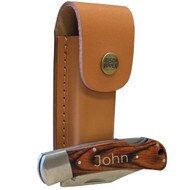 Custom Stainless Steel And Pakkawood Folding Knife Featuring Engraved Name Sitting In Front Of Light Leather Sheath