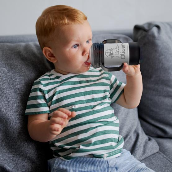 Custom Engraved 10 White Sippy Cup held by toddler with a sample engraving for Oliver