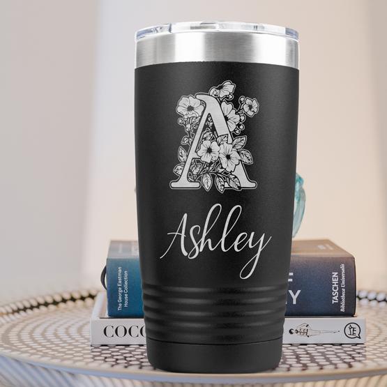 Custom Engraved 20 oz Black Tumbler on a side table with books