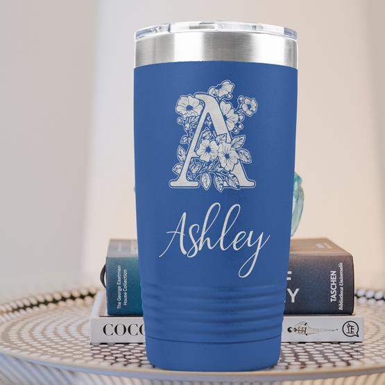 Custom Engraved 20 oz Blue Tumbler on a side table with books