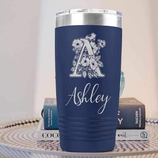 Custom Engraved 20 oz Navy Tumbler on a side table with books