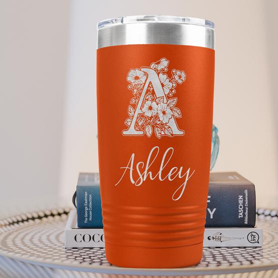 Custom Engraved 20 oz Orange Tumbler on a side table with books