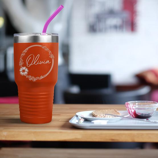 Custom Engraved 30 oz Orange Tumbler on a table next to breakfast with a sample engraving for Olivia