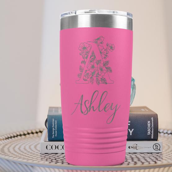 Custom Engraved 20 oz Pink Tumbler on a side table with books