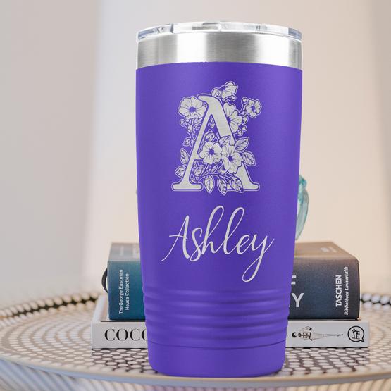 Custom Engraved 20 oz Purple Tumbler on a side table with books