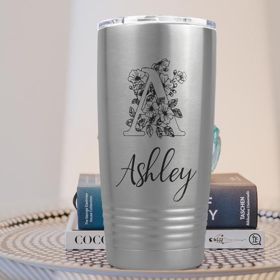 Custom Engraved 20 oz Silver Tumbler on a side table with books