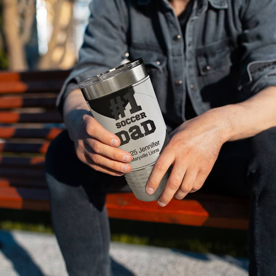 Man On Bench Outdoors Holding Soccer Wrapped Coffee Tumbler With Faux Leather Featuring Number One Soccer Dad Custom Text