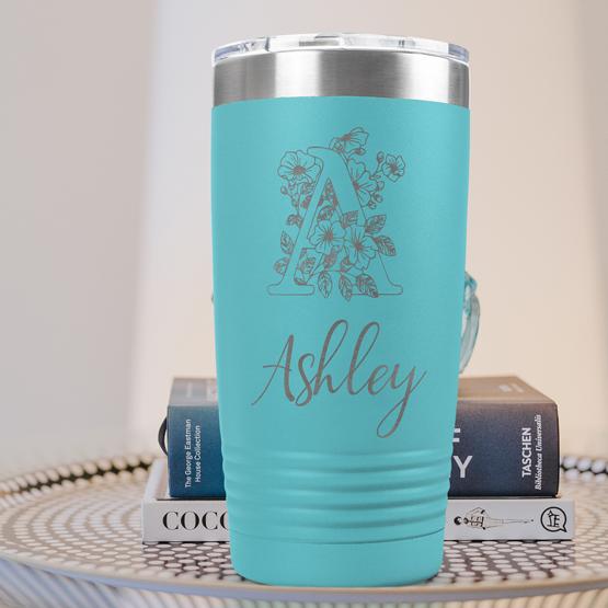 Custom Engraved 20 oz Teal Tumbler on a side table with books