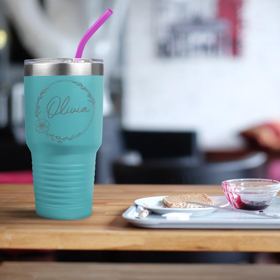 Custom Engraved 30 oz Teal Tumbler on a table next to breakfast with a sample engraving for Olivia