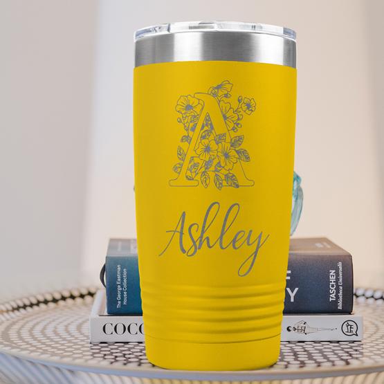 Custom Engraved 20 oz Yellow Tumbler on a side table with books