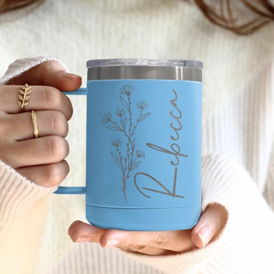 Custom Engraved 15 oz Light Blue Tumbler Mug being held by a woman with a sample engraving for Rebecca