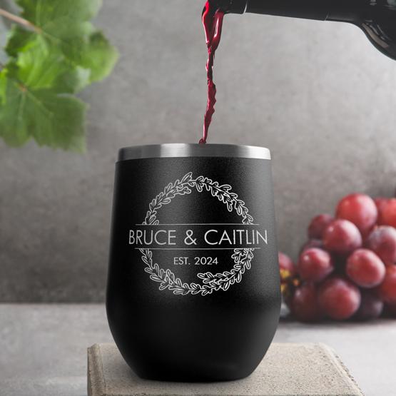 Custom Engraved 12 oz Black Wine Tumbler pouring wine with a sample engraving for Bruce & Caitlin