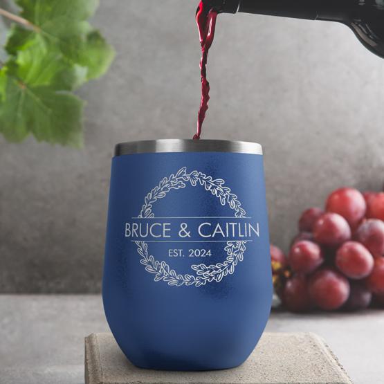 Custom Engraved 12 oz Blue Wine Tumbler pouring wine with a sample engraving for Bruce & Caitlin