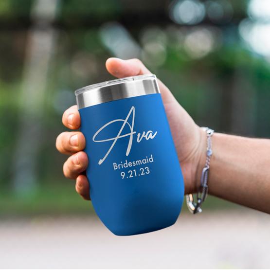 Custom Engraved 16 oz Blue Wine Tumbler held by woman with the engraving for Ava.