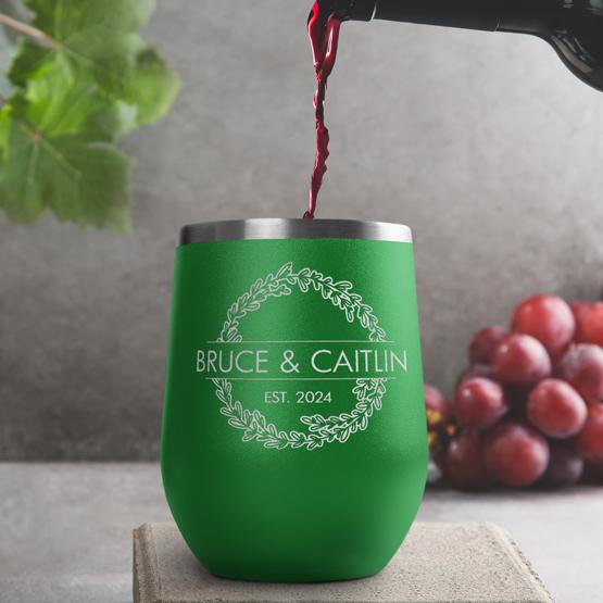 Custom Engraved 12 oz Green Wine Tumbler pouring wine with a sample engraving for Bruce & Caitlin