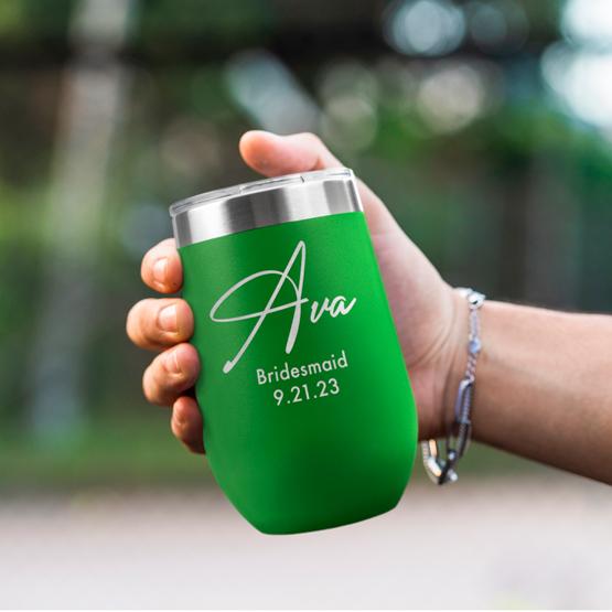 Custom Engraved 16 oz Green Wine Tumbler held by woman with the engraving for Ava.