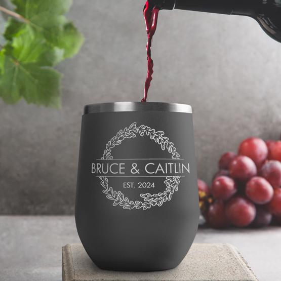 Custom Engraved 12 oz Gray Wine Tumbler pouring wine with a sample engraving for Bruce & Caitlin