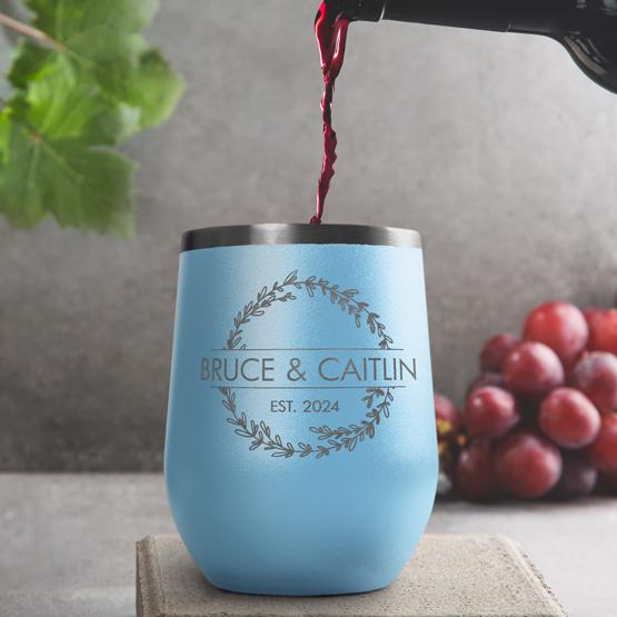 Custom Engraved 12 oz Light Blue Wine Tumbler pouring wine with a sample engraving for Bruce & Caitlin