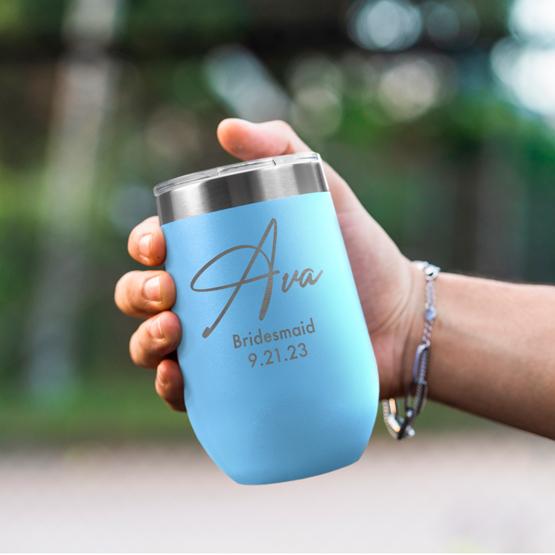 Custom Engraved 16 oz Light Blue Wine Tumbler held by woman with the engraving for Ava.