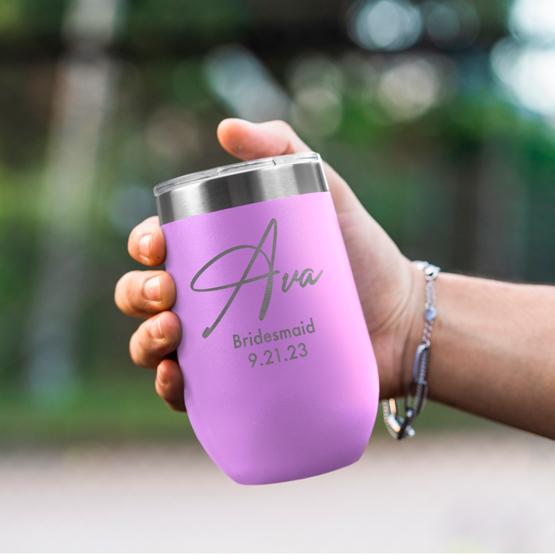 Custom Engraved 16 oz Light Purple Wine Tumbler held by woman with the engraving for Ava.