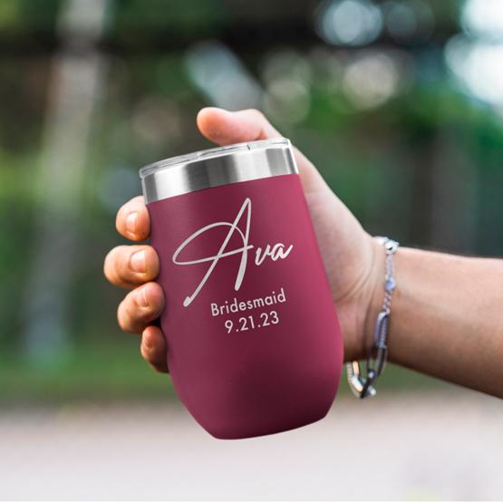 Custom Engraved 16 oz Maroon Wine Tumbler held by woman with the engraving for Ava.