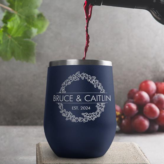 Custom Engraved 12 oz Navy Wine Tumbler pouring wine with a sample engraving for Bruce & Caitlin