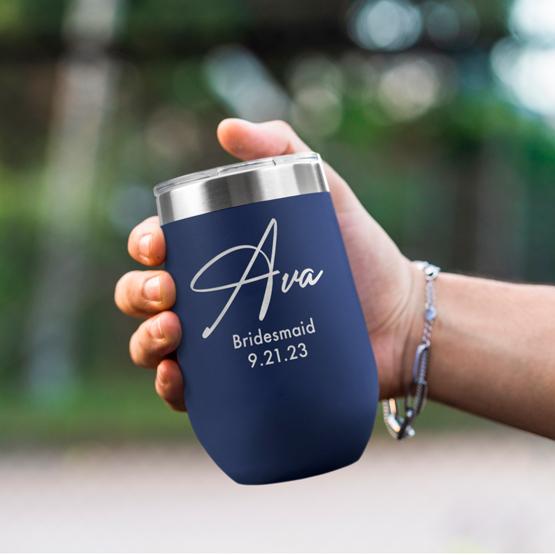 Custom Engraved 16 oz Navy Wine Tumbler held by woman with the engraving for Ava.