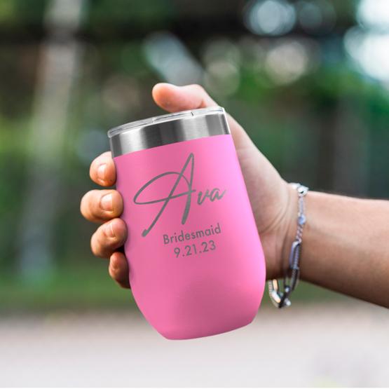 Custom Engraved 16 oz Pink Wine Tumbler held by woman with the engraving for Ava.