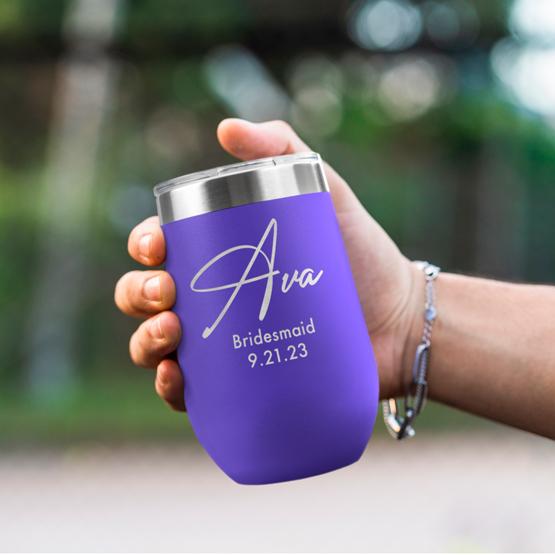 Custom Engraved 16 oz Purple Wine Tumbler held by woman with the engraving for Ava.