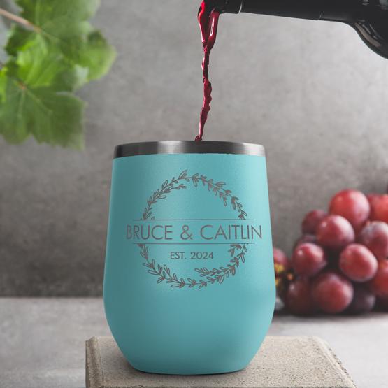 Custom Engraved 12 oz Teal Wine Tumbler pouring wine with a sample engraving for Bruce & Caitlin