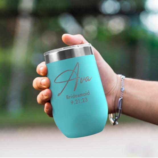 Custom Engraved 16 oz Teal Wine Tumbler held by woman with the engraving for Ava.