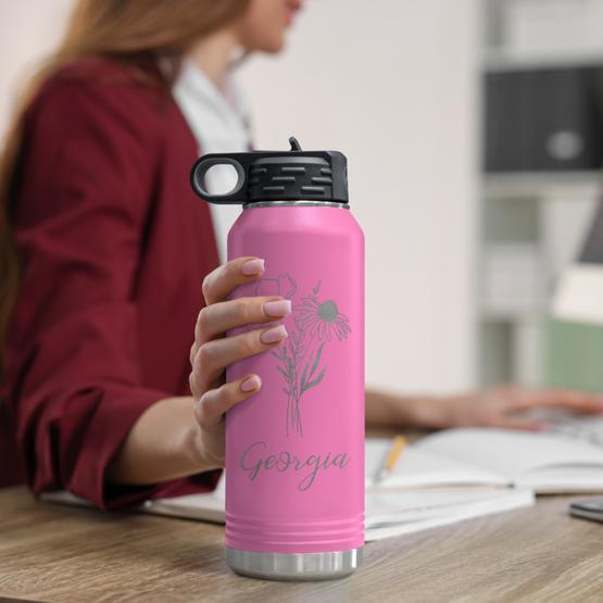 Custom Engraved 32 oz Pink Water Bottle on Woman’s Desk while she works on a computer.