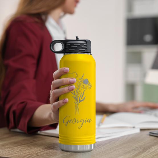 Custom Engraved 32 oz Yellow Water Bottle on Woman’s Desk while she works on a computer.