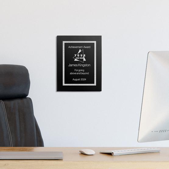 A customized Florentine plaque with silver engraving featuring a recognition award hanging in an office.