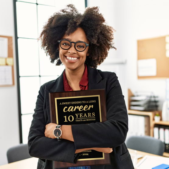 Black Woman With Glasses In Work Office Holding Custom Retirement Plaque With A Sweet End To A Long Career Text