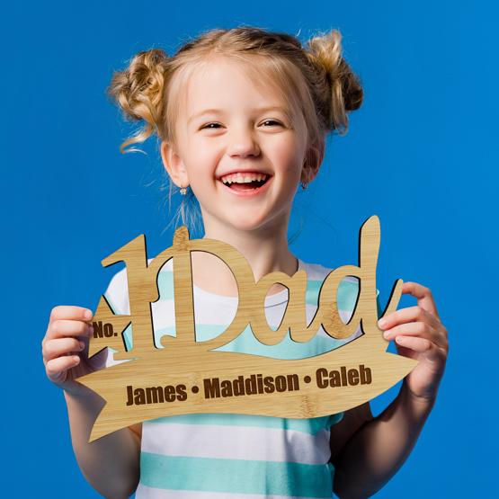 Happy Young Girl Holding Custom Engraved Bamboo Sign For Number One Dad