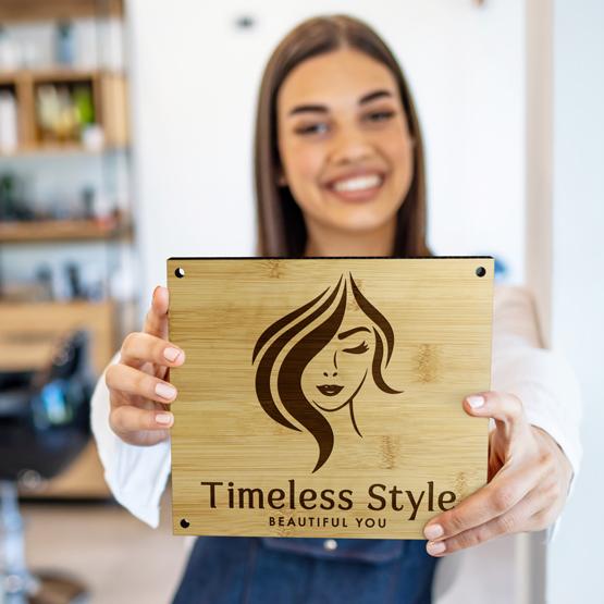 Custom Engraved Bamboo Signs with 4 Holes being held by happy woman in salon 