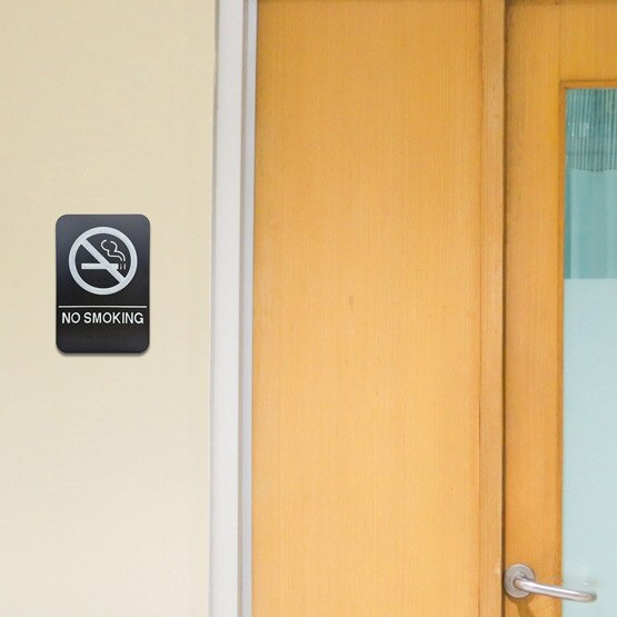 Black And White Plastic Sign With No Smoking Icon And Text And Braille On Wall Beside Interior Office Door